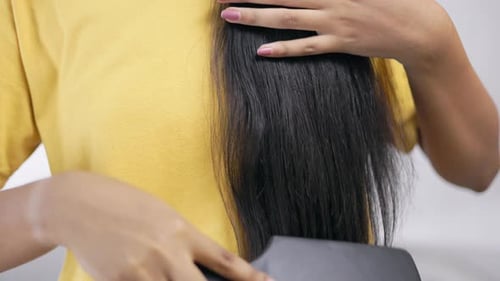 Woman Brushing Long, Straight Black Hair