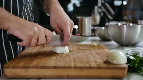 Close-Up Cook Man Hands Cut White Onion Into Slices with a Knife