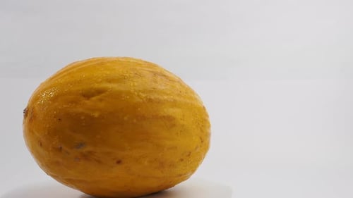 Frische Melone rotiert auf weißem Hintergrund.