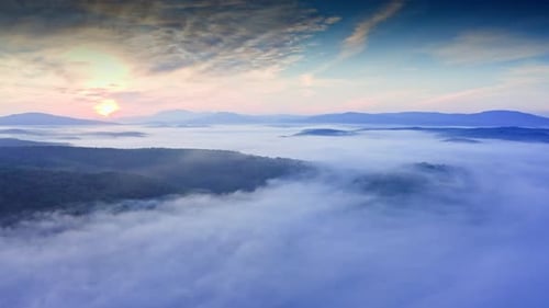 Scenic Sunrise with Clouds Flowing in Mountain Valley