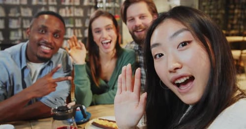 Diverse Friends Waving and Smiling in Cafe Setting
