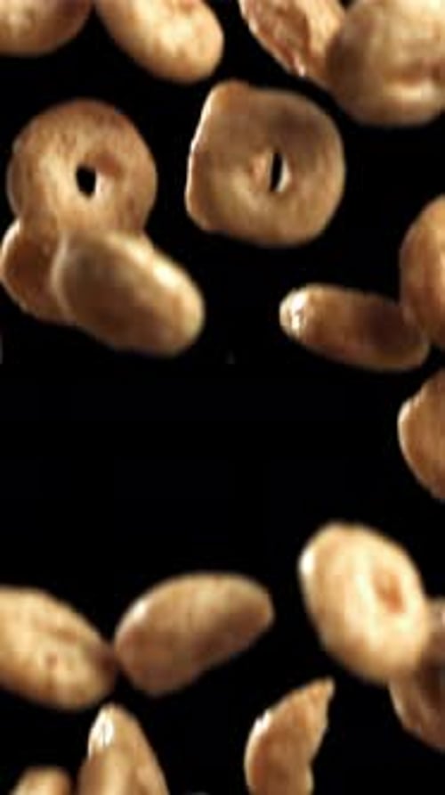 Cornflakes, die auf schwarzen Hintergrund fallen, gefilmt mit einer Hochgeschwindigkeitskamera mit 1000 Bildern pro Sekunde