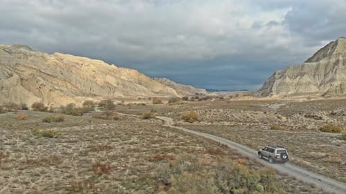 High Drone shot of 4WD Car Driving up a Caucasus Mountain in Georgia