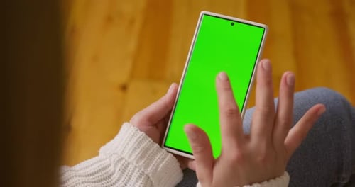 Closeup of Woman Hands Holding Smartphone with Green Screen in Vertical Position