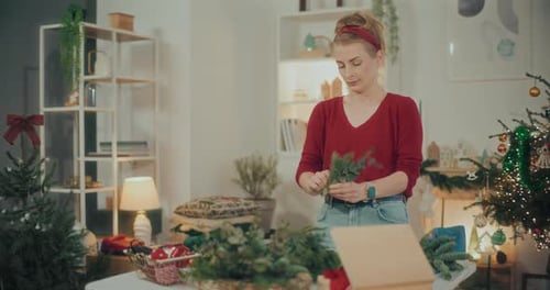 Woman Working with Pine at Table at Christmas