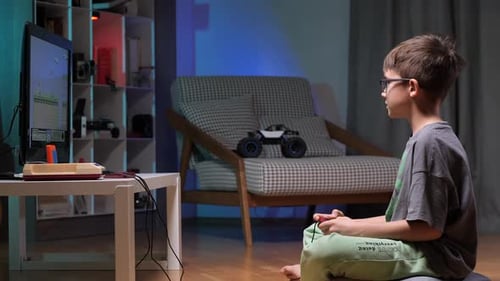 Boy Plays Vintage Video Game at Home