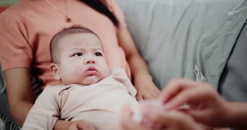 Adorable Infant Resting on Mother's Lap At Home