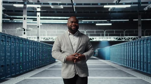 Cheerful Admin Walking in Data Center Checking Gear for System Stability