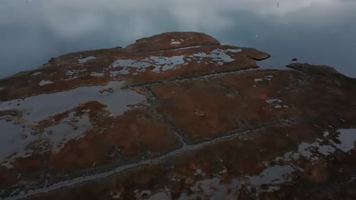 An aerial view over the salt marsh by Freeport, New York on a cloudy day. The drone camera dolly in