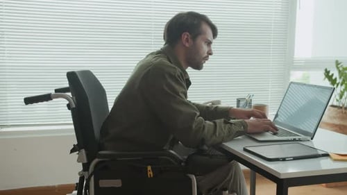 Young Adult Working at Laptop in Wheelchair
