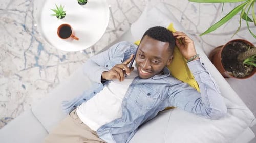 Man Talking on Phone While Lying on Couch