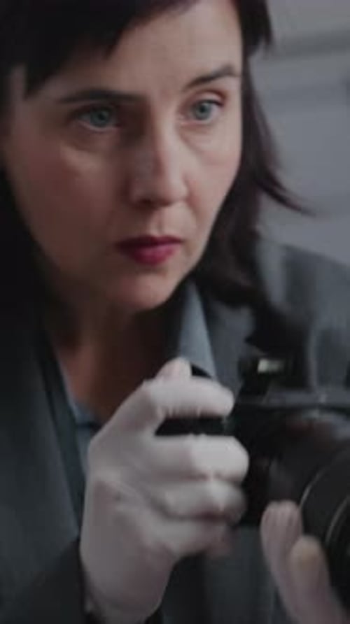 Close Up of Female Forensic Scientist Taking Photos of Evidence at Crime Scene