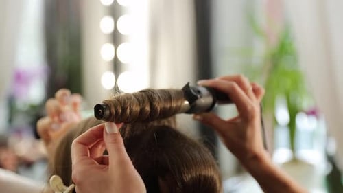 Hairdresser Creating Curls with a Curling Iron