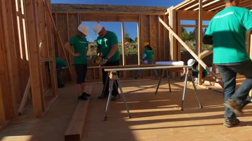 Volunteers Working Constructing House in Bright Daylight