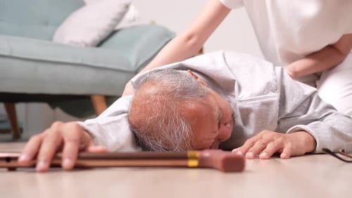Asian woman daughter or granddaughter helping senior male from falling on the ground