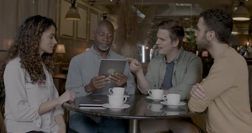 Group of Business People having Casual Meeting in Cafe using Digital tablet