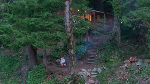 Serene Evening By the Riverside Forest Cabin With Girl Relaxing By Campfire