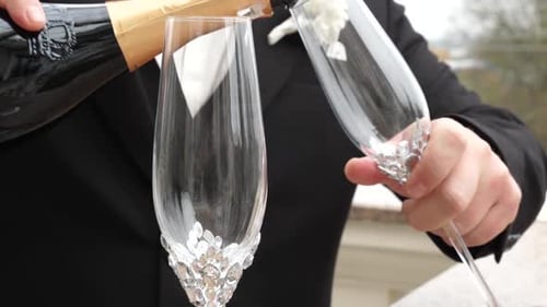 Filling Champagne Glasses with Bubbly Liquid for Celebration