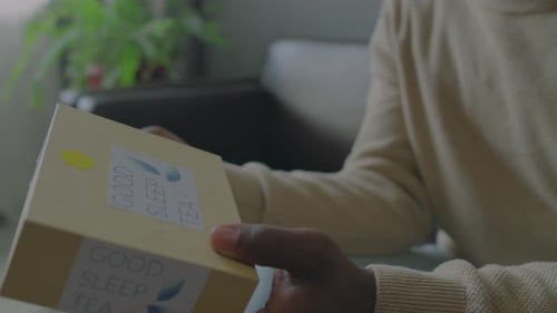 Man Holding Box of Sleep Tea and Consulting with Doctor