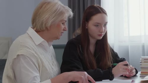 Teen Girl Receives Homework Help From Adult Woman
