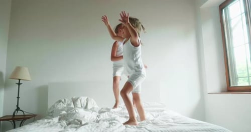 Excited Girls Jumping and Playing on Bed