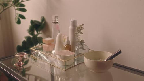 Beauty Skincare Products and Tools on Glass Table in Modern Bathroom