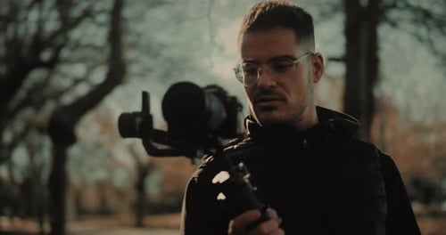 Young Man with Camera Stabilizer in Woods