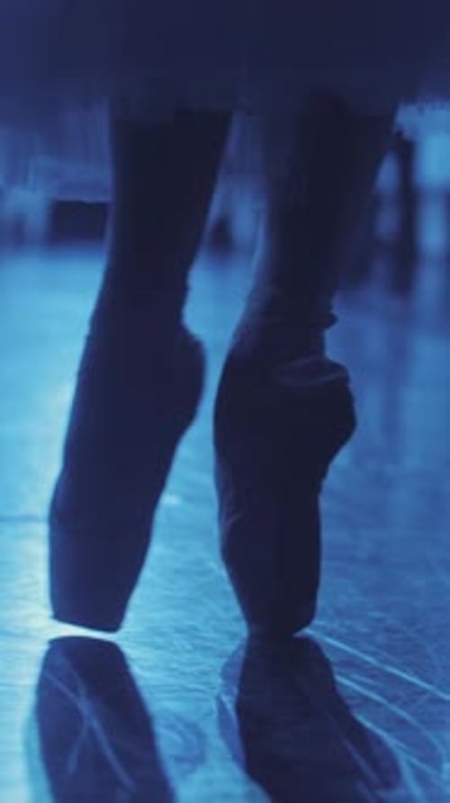 Close up of beautiful ballet dancer's legs in pointe. Woman practices exercises on stage. Ballerina