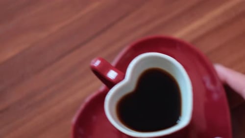 Heart Coffee Mug on Red Saucer on Table