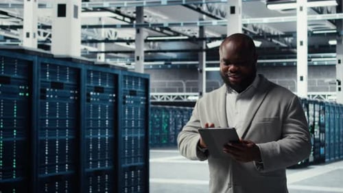 Fröhlicher Rechenzentrumsprogrammierer verwendet Tablet zur Verwaltung von Softwareupdates