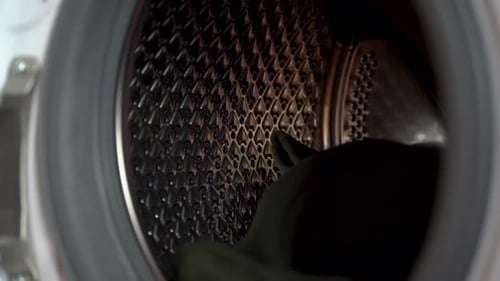 Placing Clothes into Front Load Washing Machine