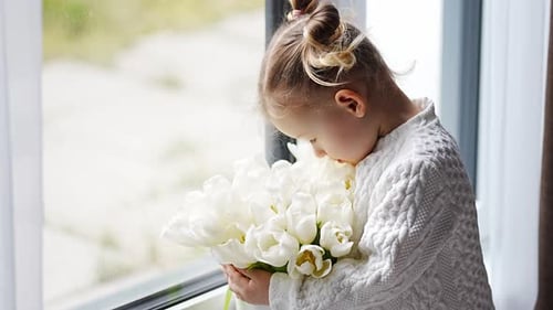 Child Holding White Tulips Near Bright Window