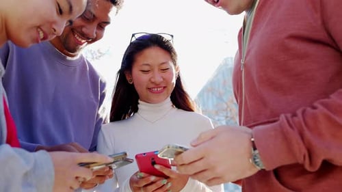 Smiling Friends Using Smartphones Together Outside