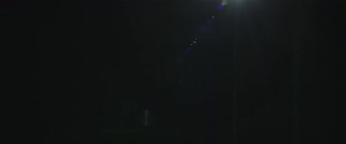 Nano Collection: Glowing particles flowing in smooth green lines moving in circular motions on a dar