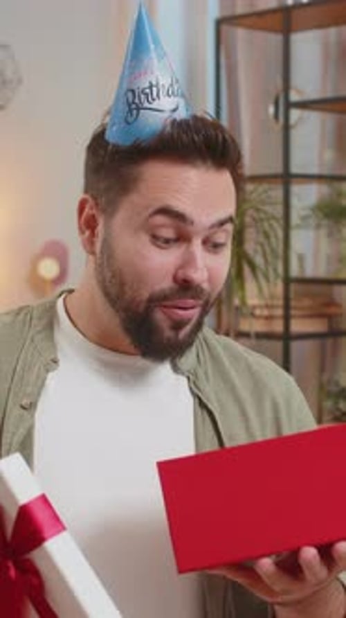Man Opening a Birthday Gift and Smiling