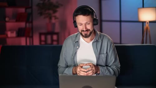 Man with Headphones Video Conferencing on Laptop