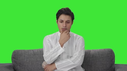 Sad Indian man counting money Green screen
