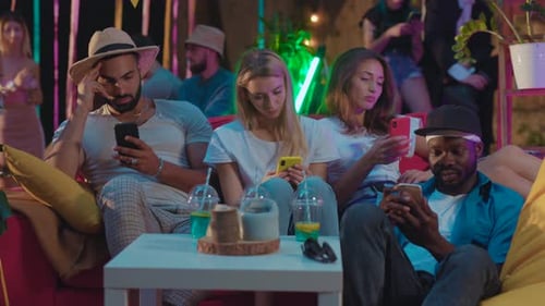 Young Adults Using Phones at Outdoor Party