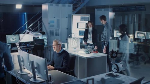 Engineers Working with Computers and Blueprints in Office