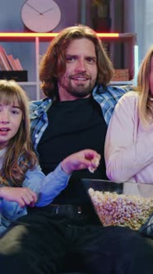Close Up of Goodlooking Terrified Excited Couple with Their Two Kids Which Viewing Horror Film on TV
