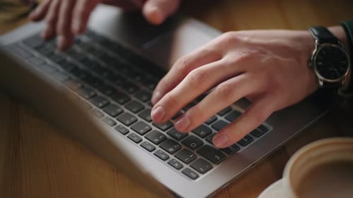 Hands Typing on Silver Laptop Keyboard Close Up
