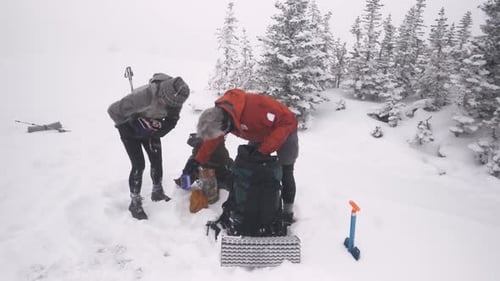 Couple Setting Up Camp in Snow Active