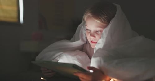 Girl Using Tablet Computer at Night