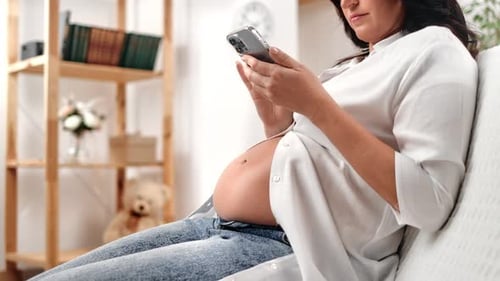 Pregnant Woman Using Phone at Home