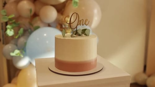 Festive stylish baby birthday cake decorated gold inscription one and green eucalyptus branch, paste