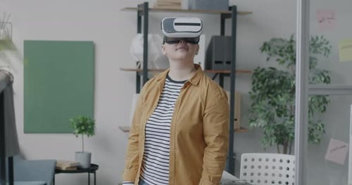 Young Lady Wearing Virtual Reality Glasses Looking Around Enjoying Cyberspace Standing in Office