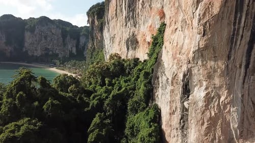 Ascending Drone Aerial View on Steep Limestone Cliffs Over Exotic Railay Beach, Krabi Thailand