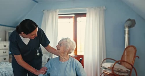 Healthcare Worker Comforts Senior Woman in Light Blue Room