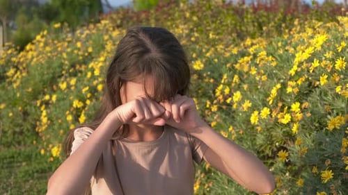 Girl Rubs Eyes in Field of Yellow Flowers