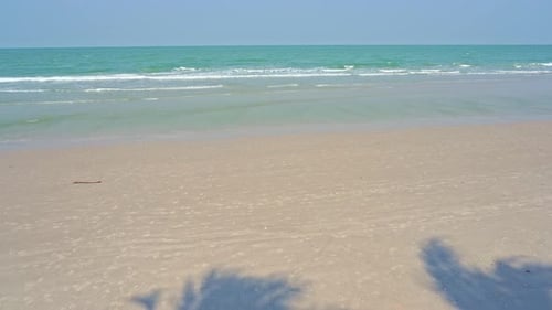Tropical beach with a white sandy beach and skyscape view. Soft waves on the beach.